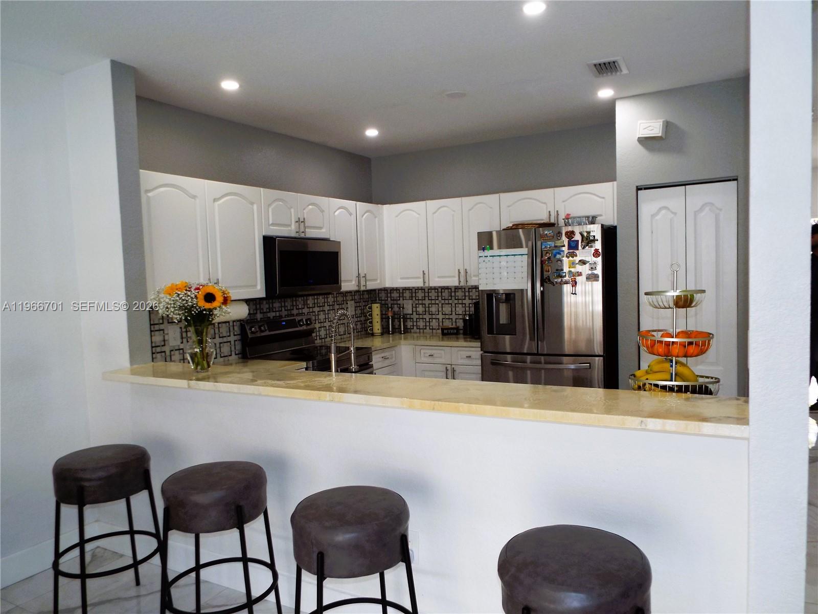 21470 Southwest 85th Path Cutler Bay, FL 33189 - Photo 14 of 50 a kitchen with stainless steel appliances granite countertop a dining table and chairs