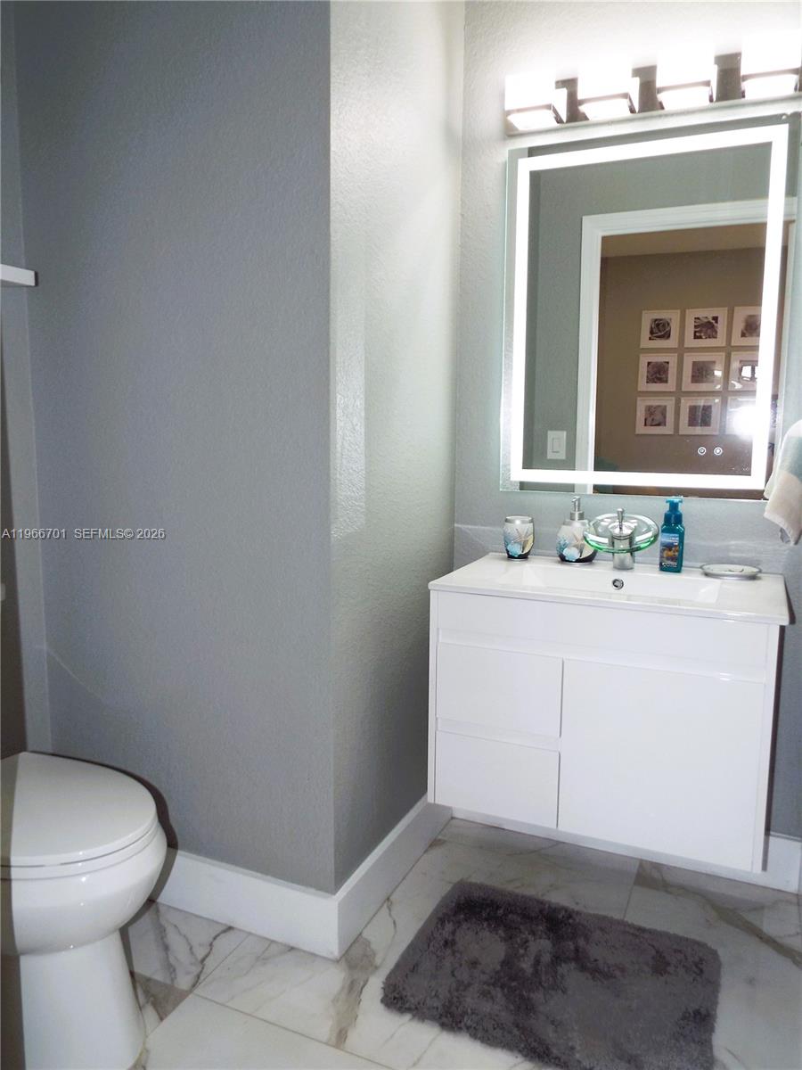 21470 Southwest 85th Path Cutler Bay, FL 33189 - Photo 18 of 50 a bathroom with a sink a toilet and mirror