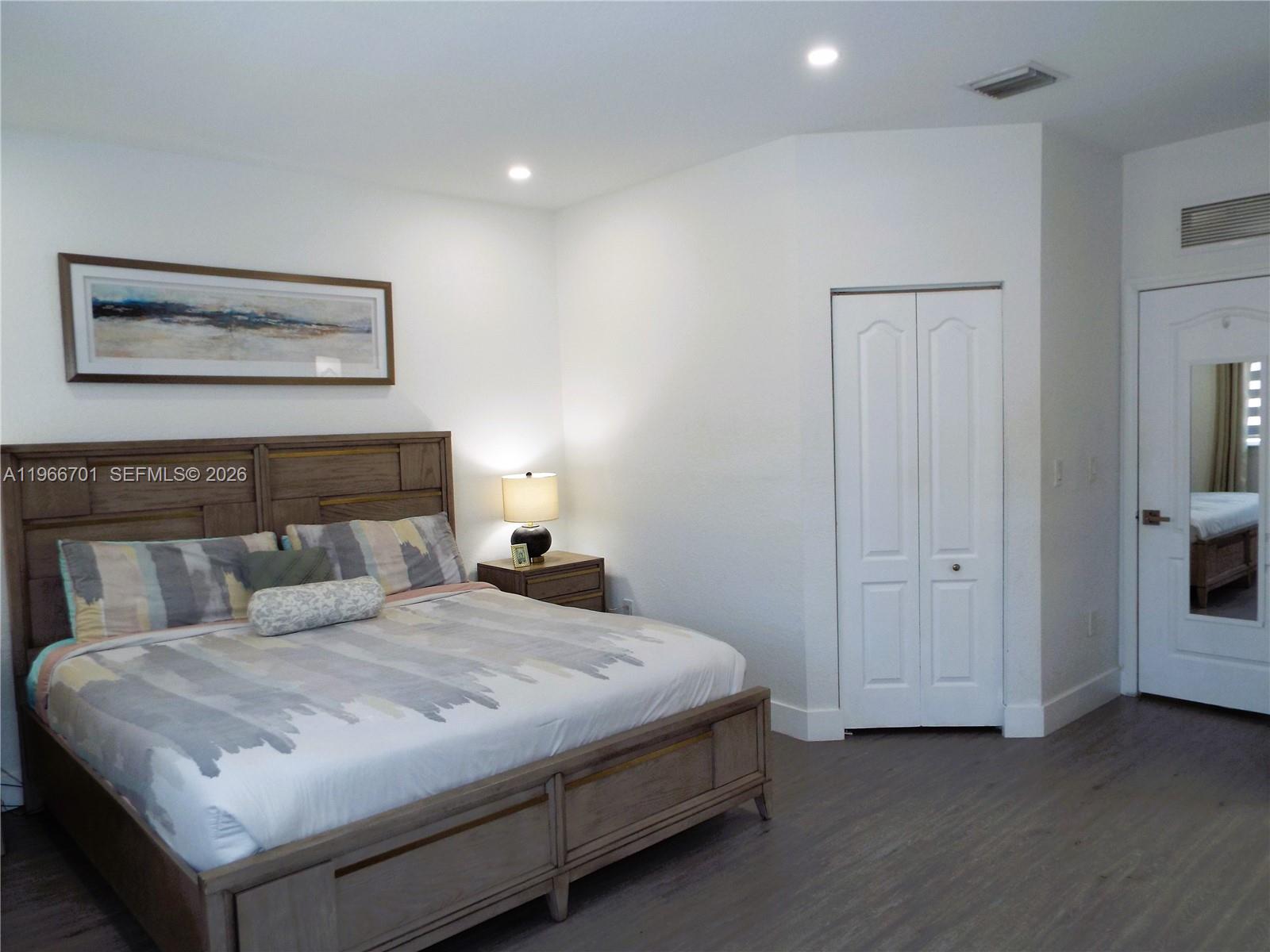 21470 Southwest 85th Path Cutler Bay, FL 33189 - Photo 38 of 50 a bedroom with a bed and a night stand