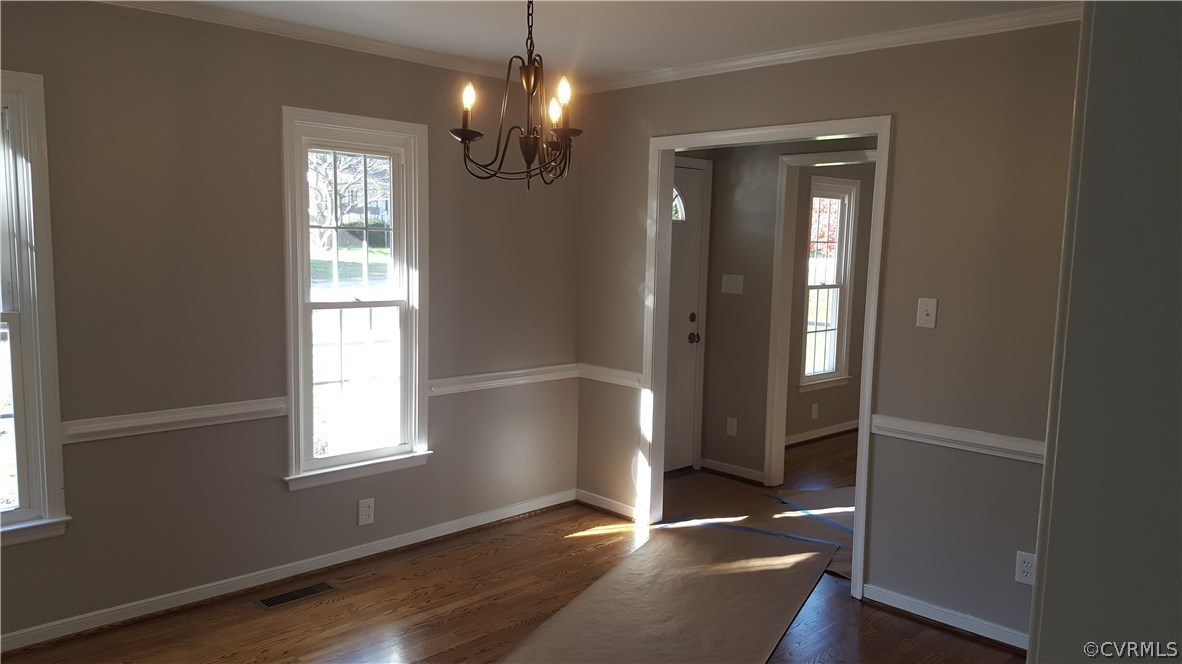 1613 Wilson Wood Road Midlothian, VA 23114 - Photo 7 of 37 an empty room with wooden floor chandelier and windows