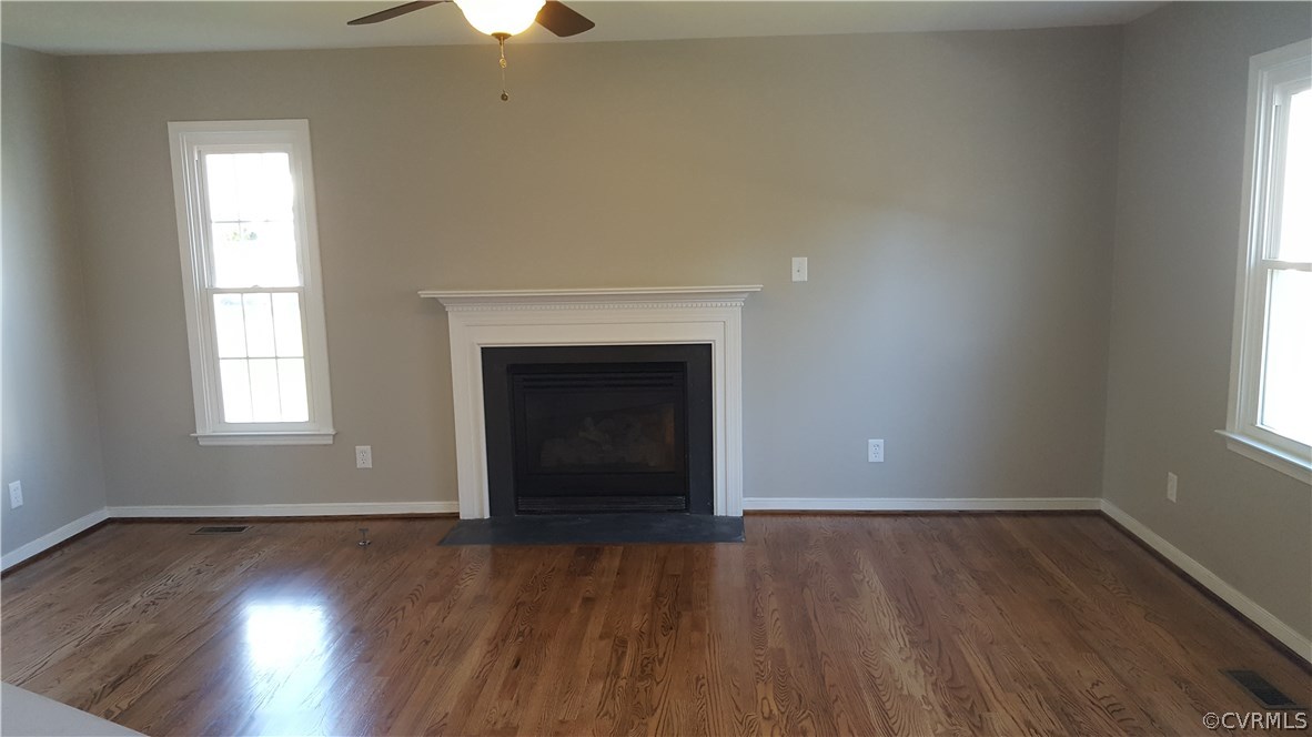 1613 Wilson Wood Road Midlothian, VA 23114 - Photo 9 of 37 an empty room with wooden floor a chandelier fan and windows