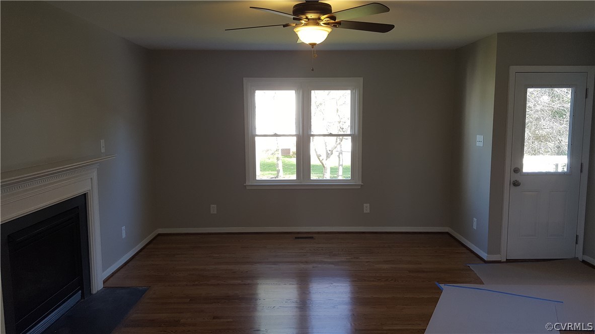 1613 Wilson Wood Road Midlothian, VA 23114 - Photo 10 of 37 an empty room with wooden floor a ceiling fan and windows