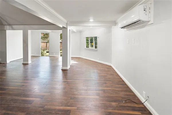 a view of empty room with wooden floor