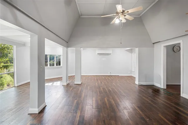 a view of a hallway with wooden floor and windows