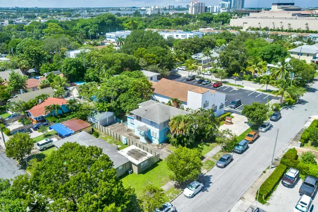 an aerial view of residential houses with outdoor space and trees all around