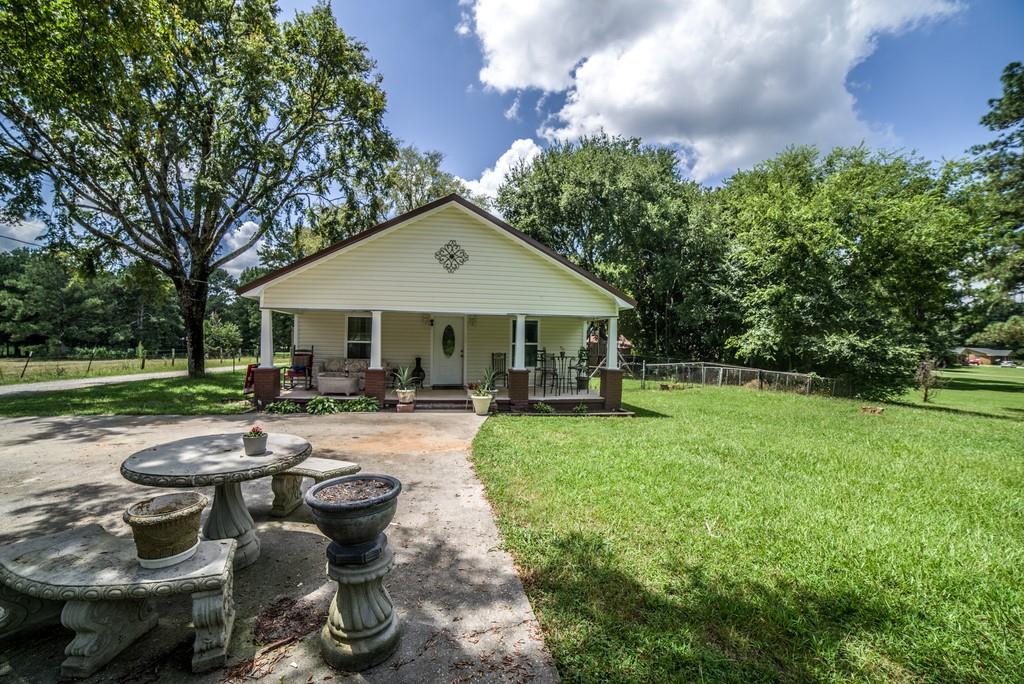 a view of a house with backyard sitting area and garden