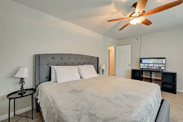 a bedroom with a bed and a tv on a dresser