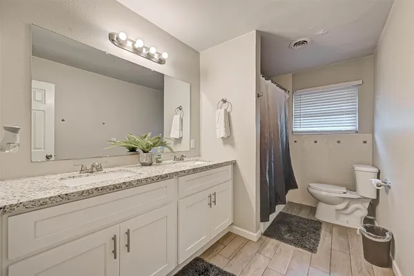 a bathroom with a granite countertop sink toilet and shower