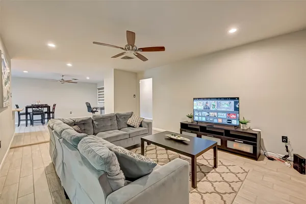a kitchen with kitchen island granite countertop a refrigerator a stove top oven a sink and dishwasher with wooden floor
