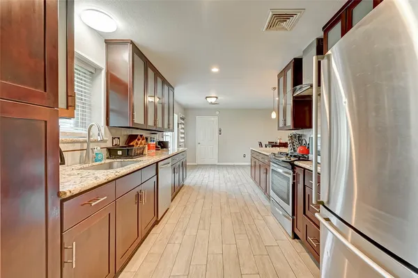 a kitchen with kitchen island granite countertop lots of counter top space and stainless steel appliances
