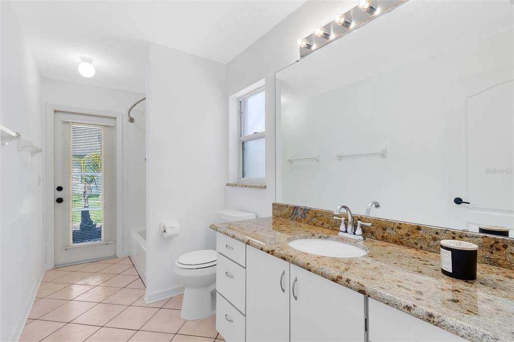 5809 Donnelly Circle Orlando, FL 32821 - Photo 17 of 22 a bathroom with a granite countertop sink a toilet and shower