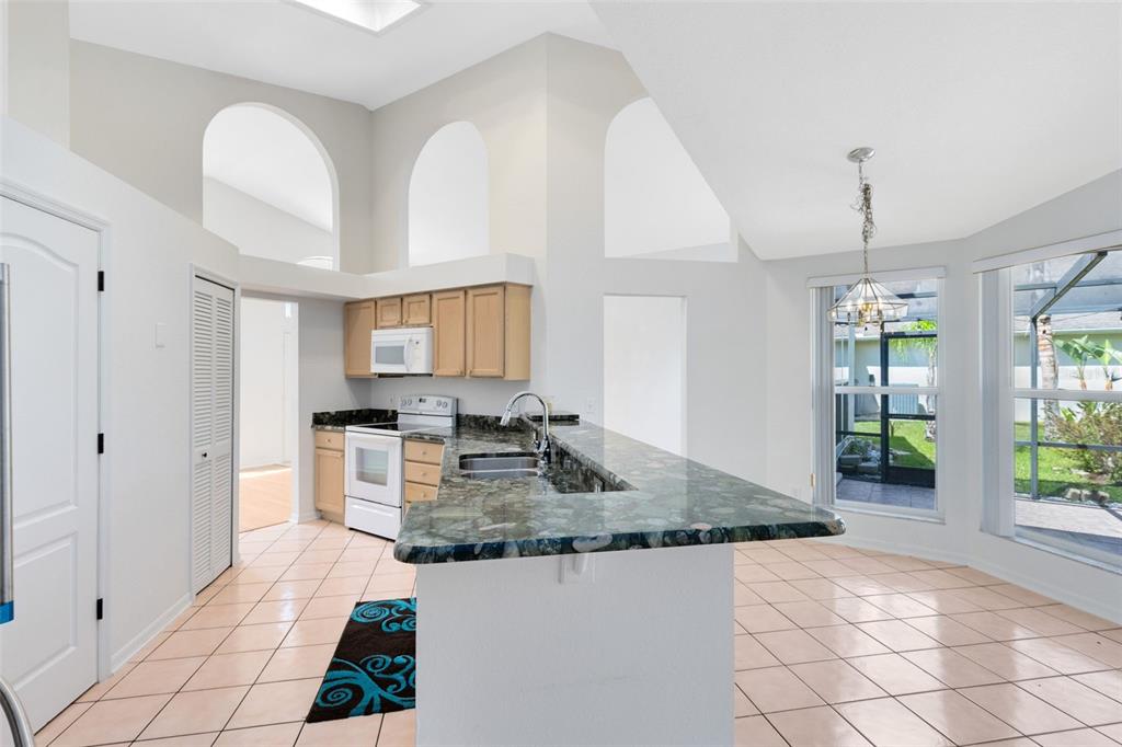 5809 Donnelly Circle Orlando, FL 32821 - Photo 10 of 22 a kitchen with kitchen island granite countertop a stove a sink a counter top space and cabinets