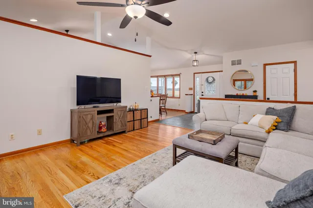 a living room with furniture a fireplace and wooden floor