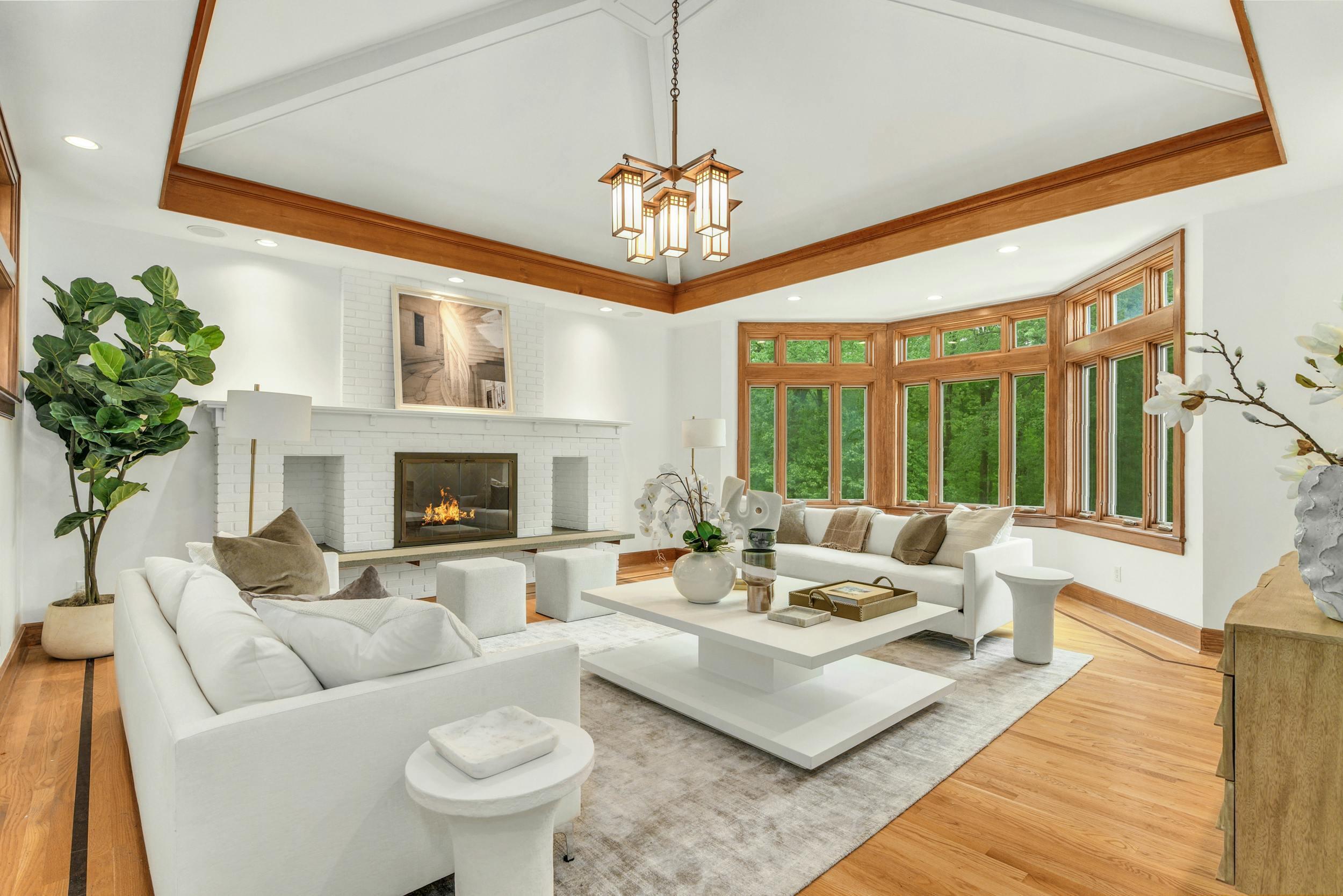 a living room with furniture a chandelier and a fireplace
