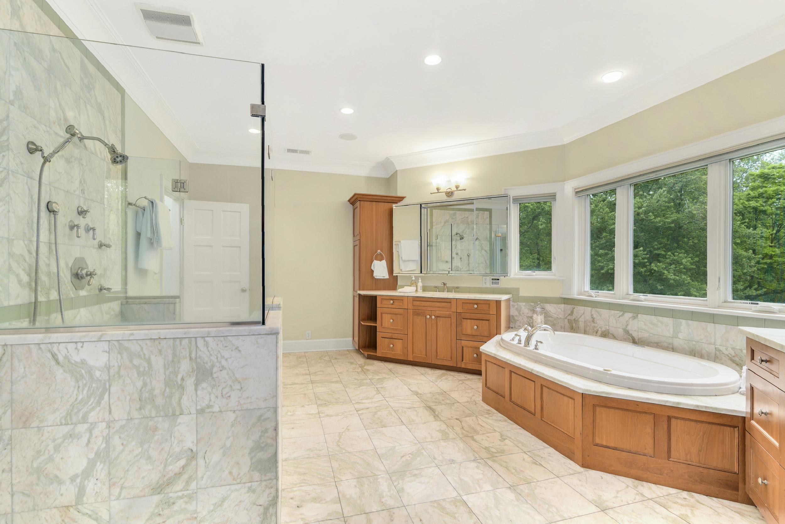 1315 Smith Ridge Road New Canaan, CT 06840 - Photo 22 of 54 a spacious bathroom with a tub sink shower and mirror
