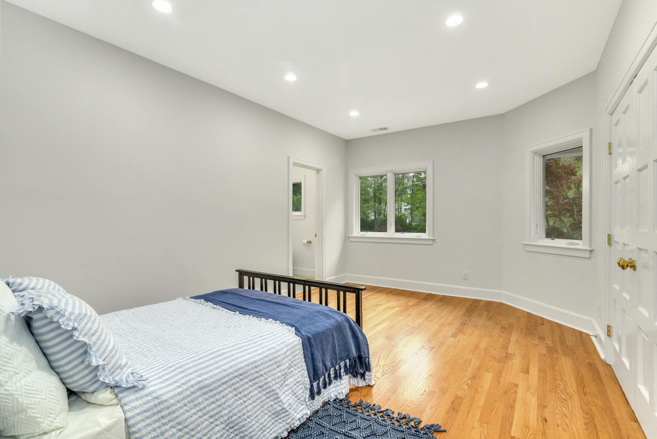 1315 Smith Ridge Road New Canaan, CT 06840 - Photo 31 of 54 a spacious bedroom with a bed and wooden floor