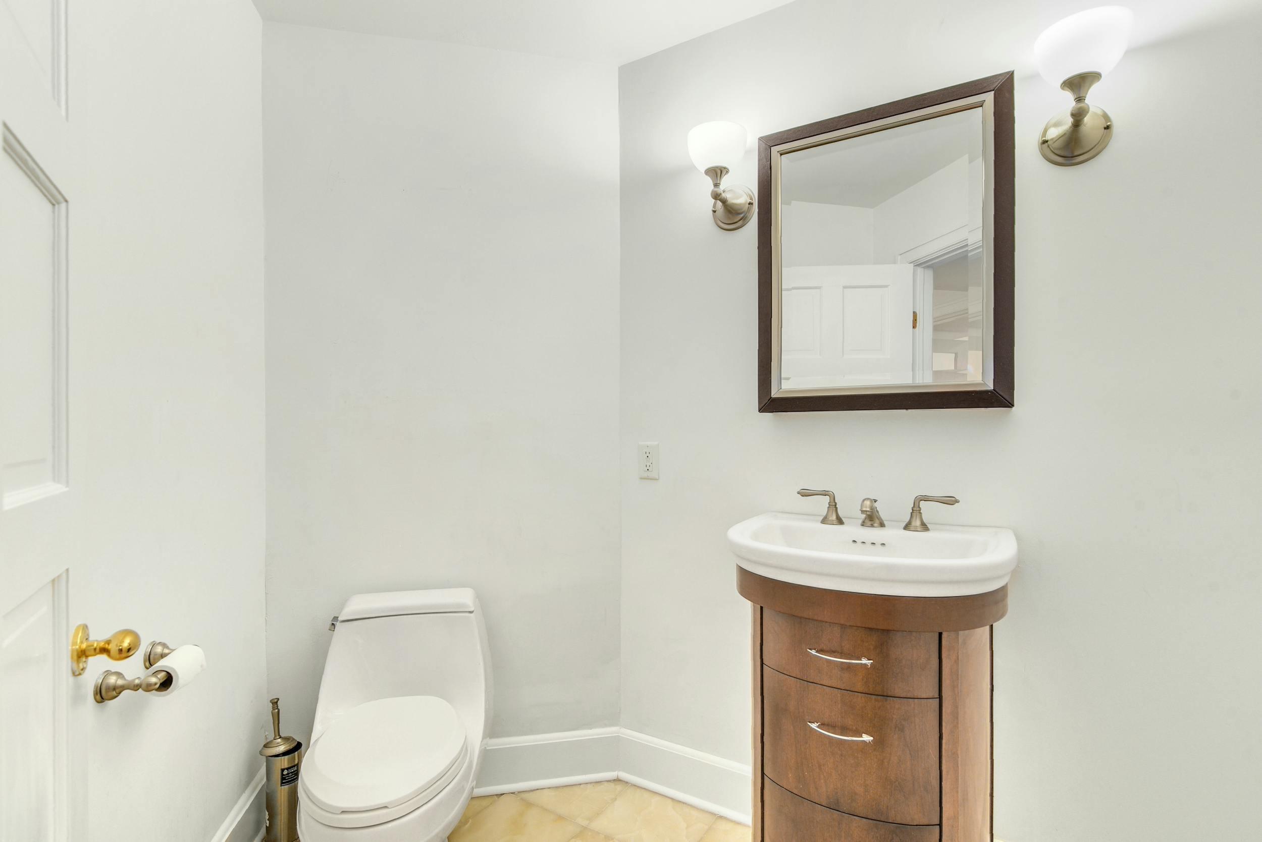 1315 Smith Ridge Road New Canaan, CT 06840 - Photo 42 of 54 a bathroom with a toilet sink and mirror