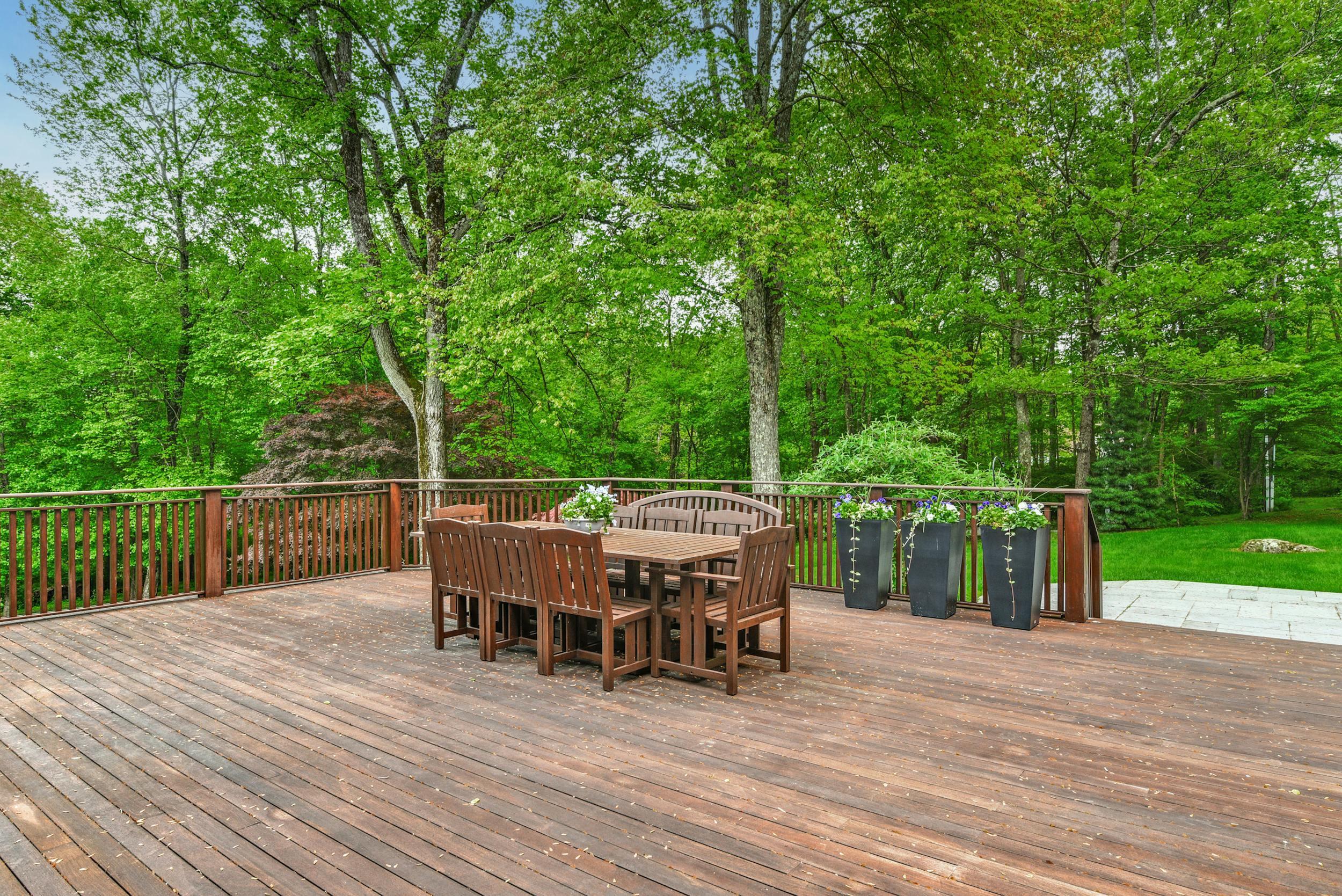 1315 Smith Ridge Road New Canaan, CT 06840 - Photo 43 of 54 a view of a roof deck with table and chairs and wooden floor