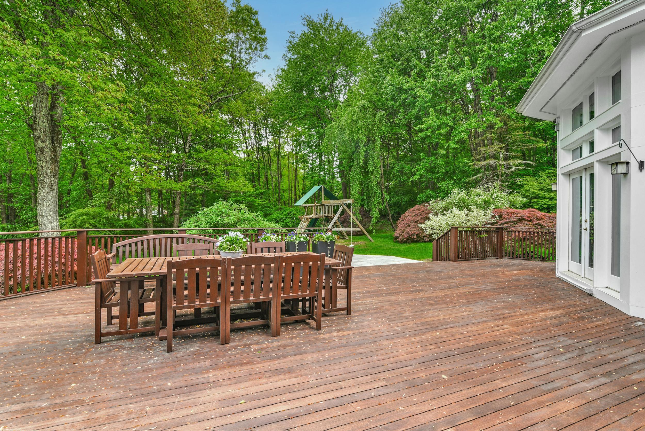 1315 Smith Ridge Road New Canaan, CT 06840 - Photo 44 of 54 a view of a patio with table and chairs with wooden floor and fence