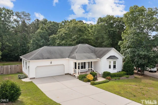 a front view of a house with a yard garage and outdoor seating