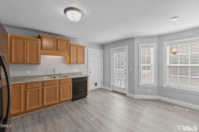a kitchen with granite countertop a stove a sink and a microwave