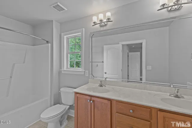 a bathroom with a granite countertop sink a toilet and a shower