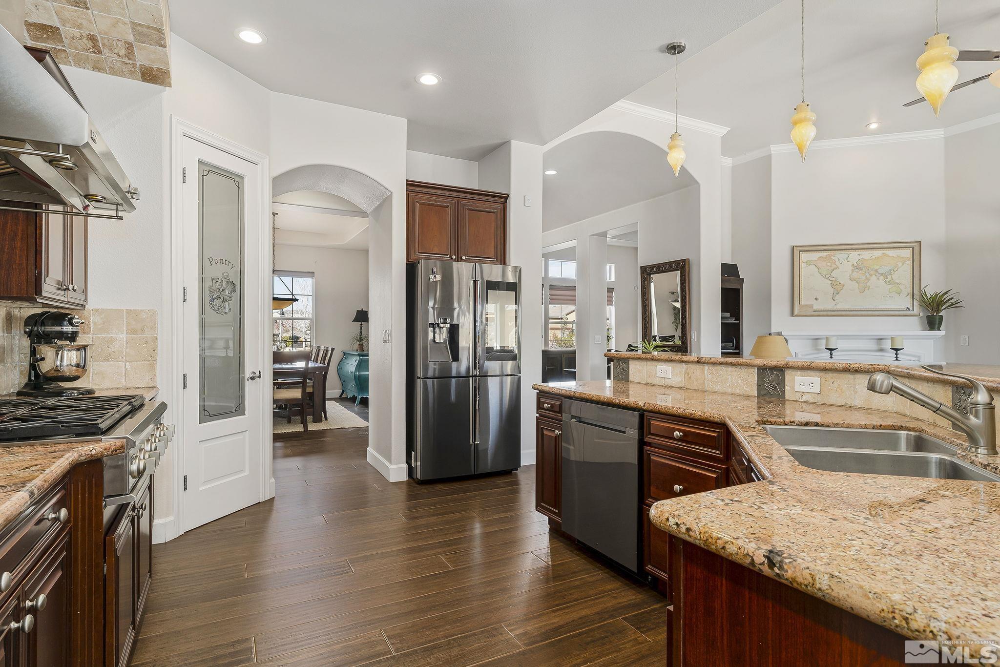 3528 Desert Fox Drive Sparks, NV 89436 - Photo 7 of 35 a large kitchen with stainless steel appliances granite countertop a refrigerator a sink dishwasher a oven and a dining table with wooden floor