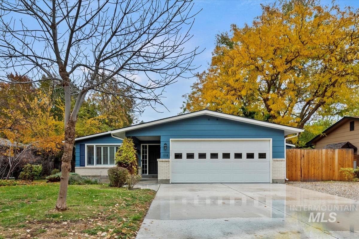 1316 Gourley Street Boise, ID 83705 - Photo 1 of 1 View of front facade with brick siding, concrete driveway, a front lawn, and an attached garage