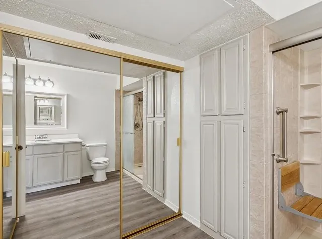 a bathroom with a granite countertop sink toilet and shower