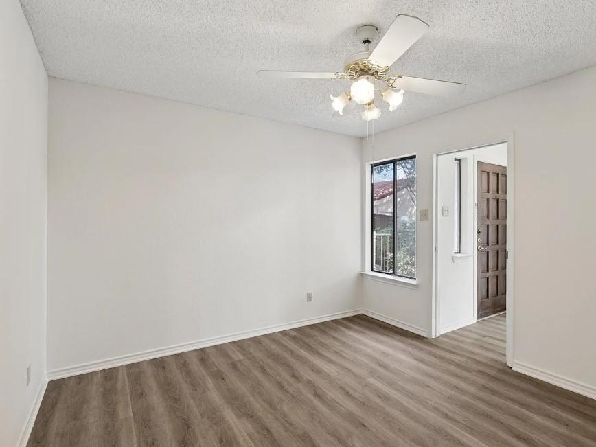 531 Ranch Trail, Unit 157 Irving, TX 75063 - Photo 17 of 21 an empty room with wooden floor chandelier fan and closet area