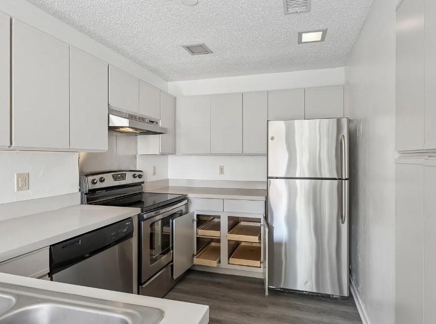 531 Ranch Trail, Unit 157 Irving, TX 75063 - Photo 6 of 21 a kitchen with a refrigerator stove and wooden floor