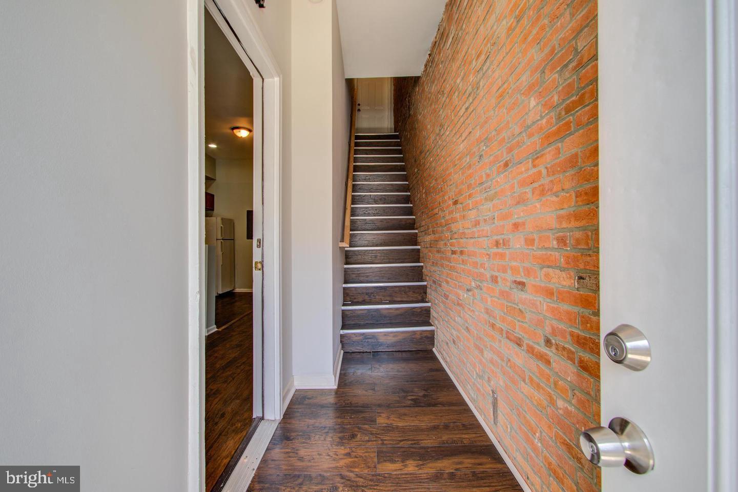 a view of a hallway with wooden floor and entryway