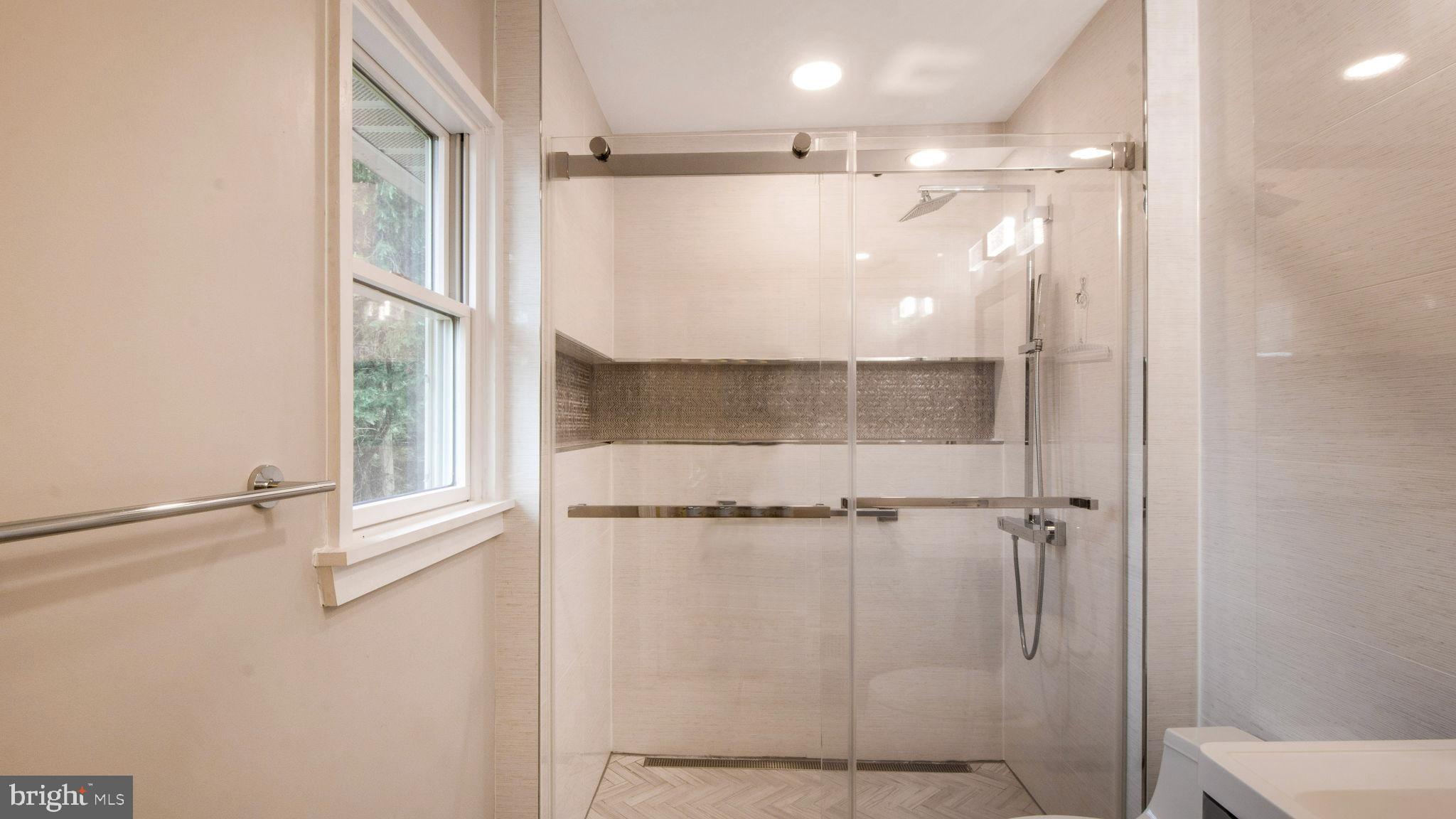 8933 Colesville Road Silver Spring, MD 20910 - Photo 15 of 31 a bathroom with a glass shower door and a window