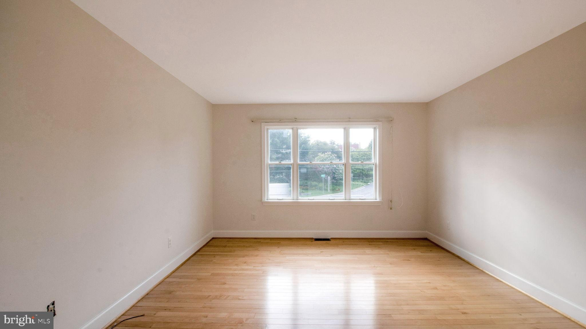 8933 Colesville Road Silver Spring, MD 20910 - Photo 20 of 31 an empty room with wooden floor and windows