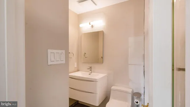 a bathroom with a sink toilet and mirror