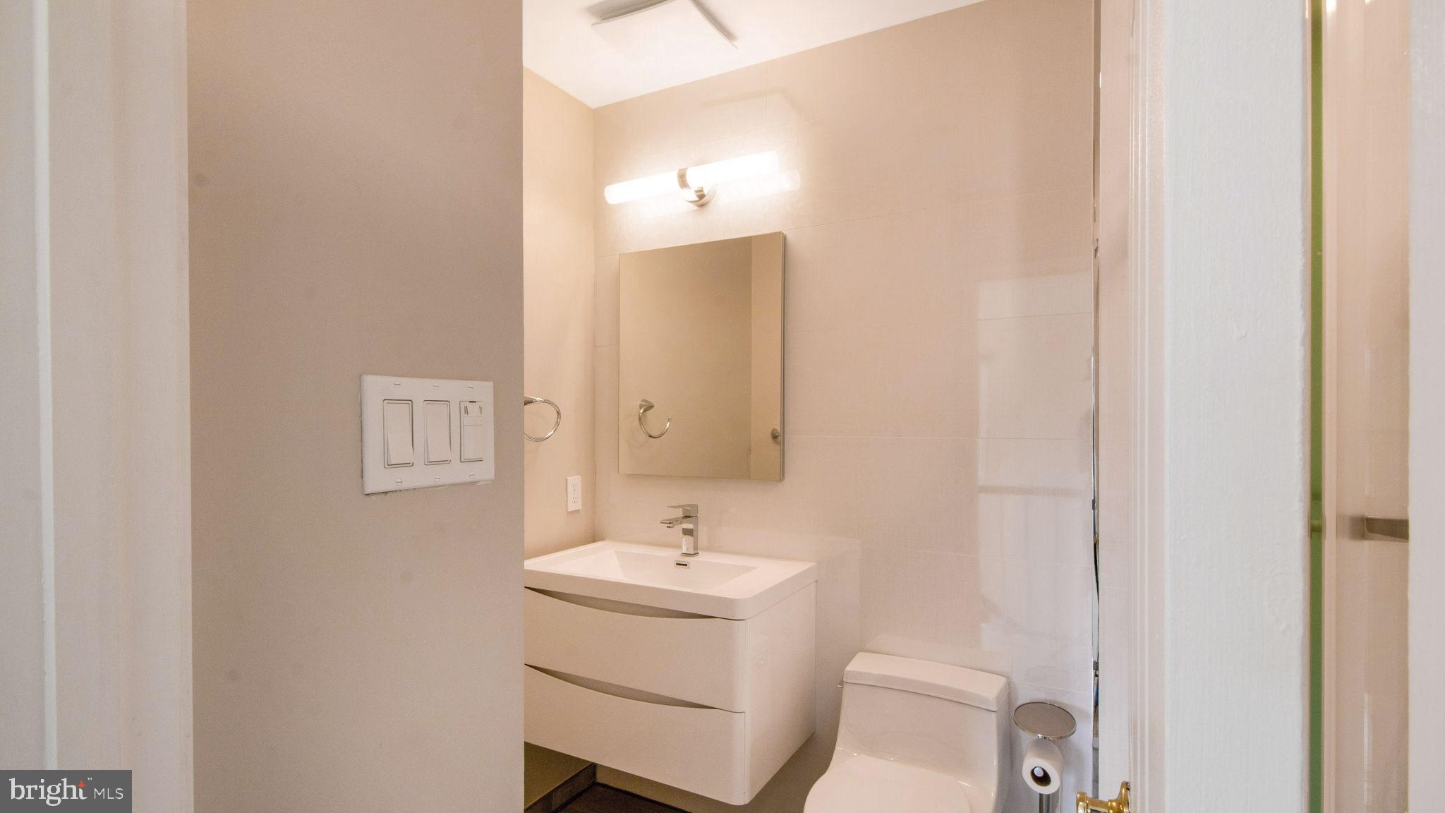 8933 Colesville Road Silver Spring, MD 20910 - Photo 23 of 31 a bathroom with a sink toilet and mirror