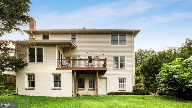 a view of a white house with a big yard and large trees