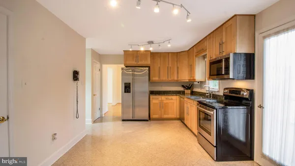 a kitchen with stainless steel appliances granite countertop a refrigerator stove and sink