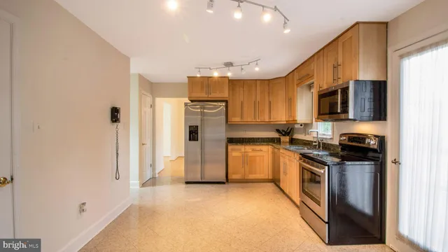 a kitchen with stainless steel appliances granite countertop a refrigerator stove and sink
