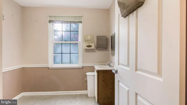 a room with a window and wooden cabinets