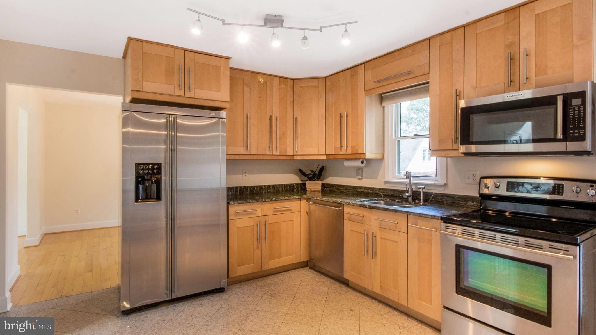 8933 Colesville Road Silver Spring, MD 20910 - Photo 6 of 31 a kitchen with stainless steel appliances granite countertop a refrigerator a stove a sink and a microwave