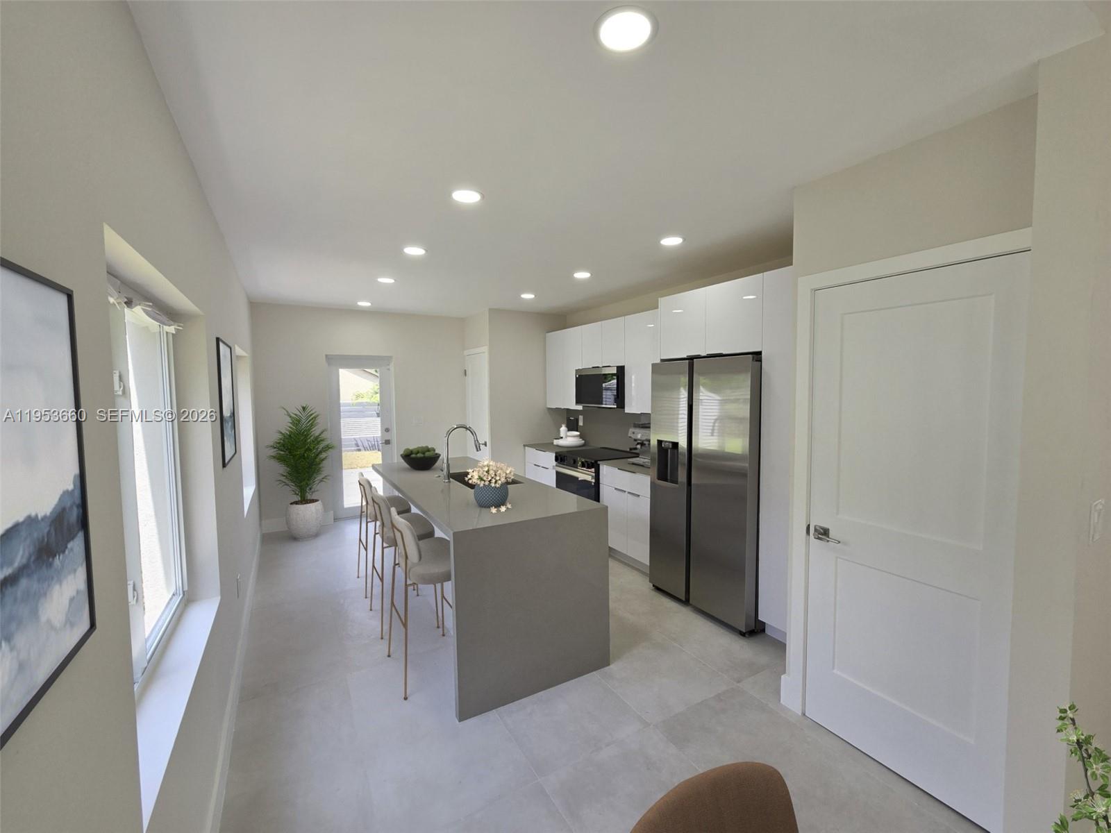 765 Northwest 45th Street Miami, FL 33127 - Photo 13 of 46 a living room with furniture a refrigerator and a sink