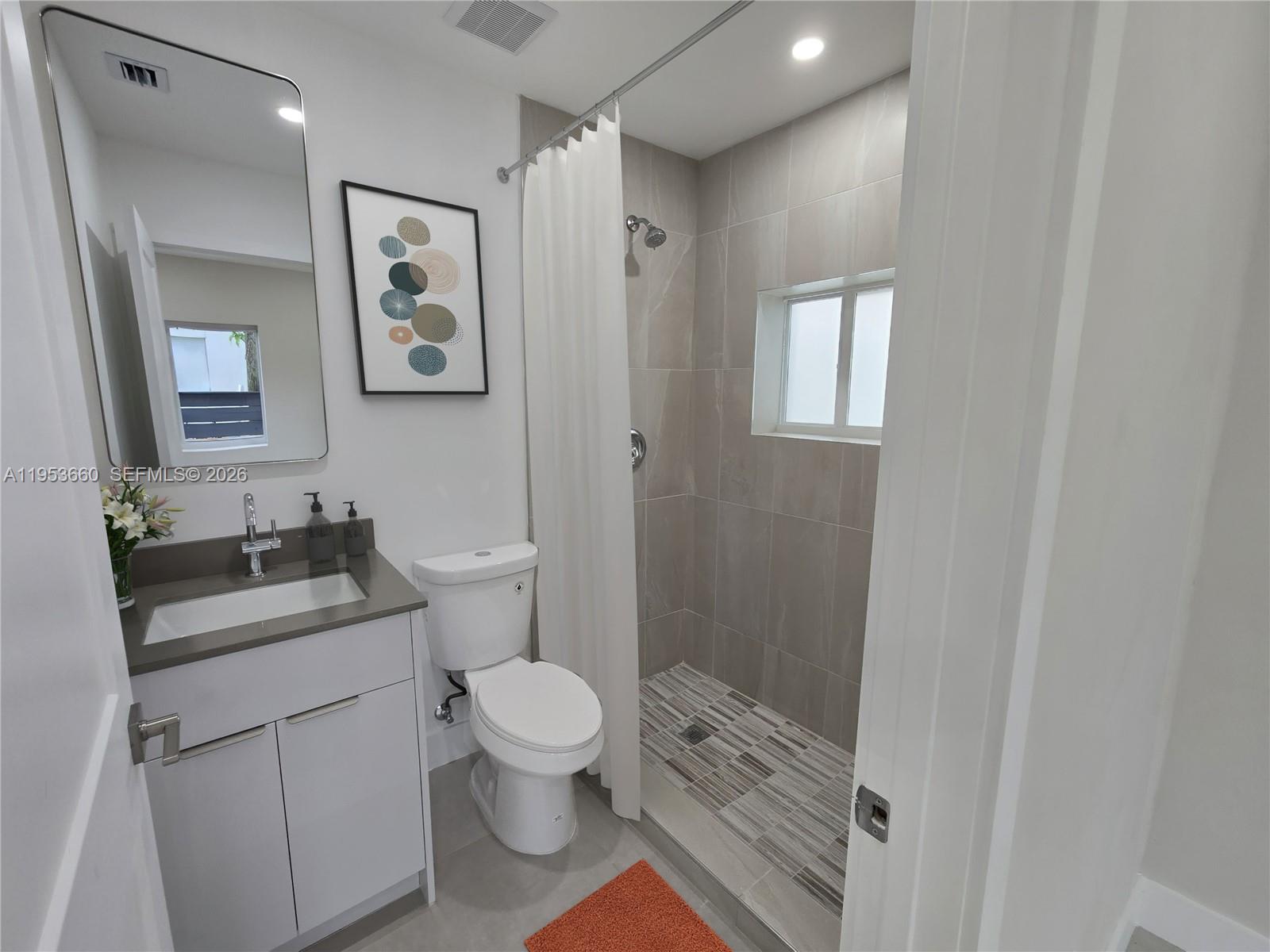 765 Northwest 45th Street Miami, FL 33127 - Photo 38 of 46 a bathroom with a granite countertop toilet sink and mirror