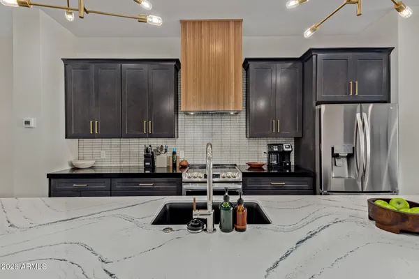 a kitchen with stainless steel appliances a refrigerator a sink a stove and cabinets
