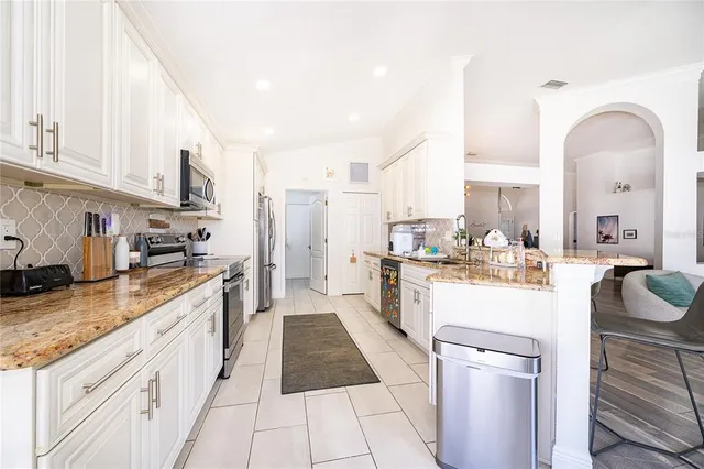 a large kitchen with a lot of counter space and stainless steel appliances