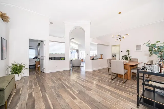 a living room with couches chairs and kitchen view with wooden floor