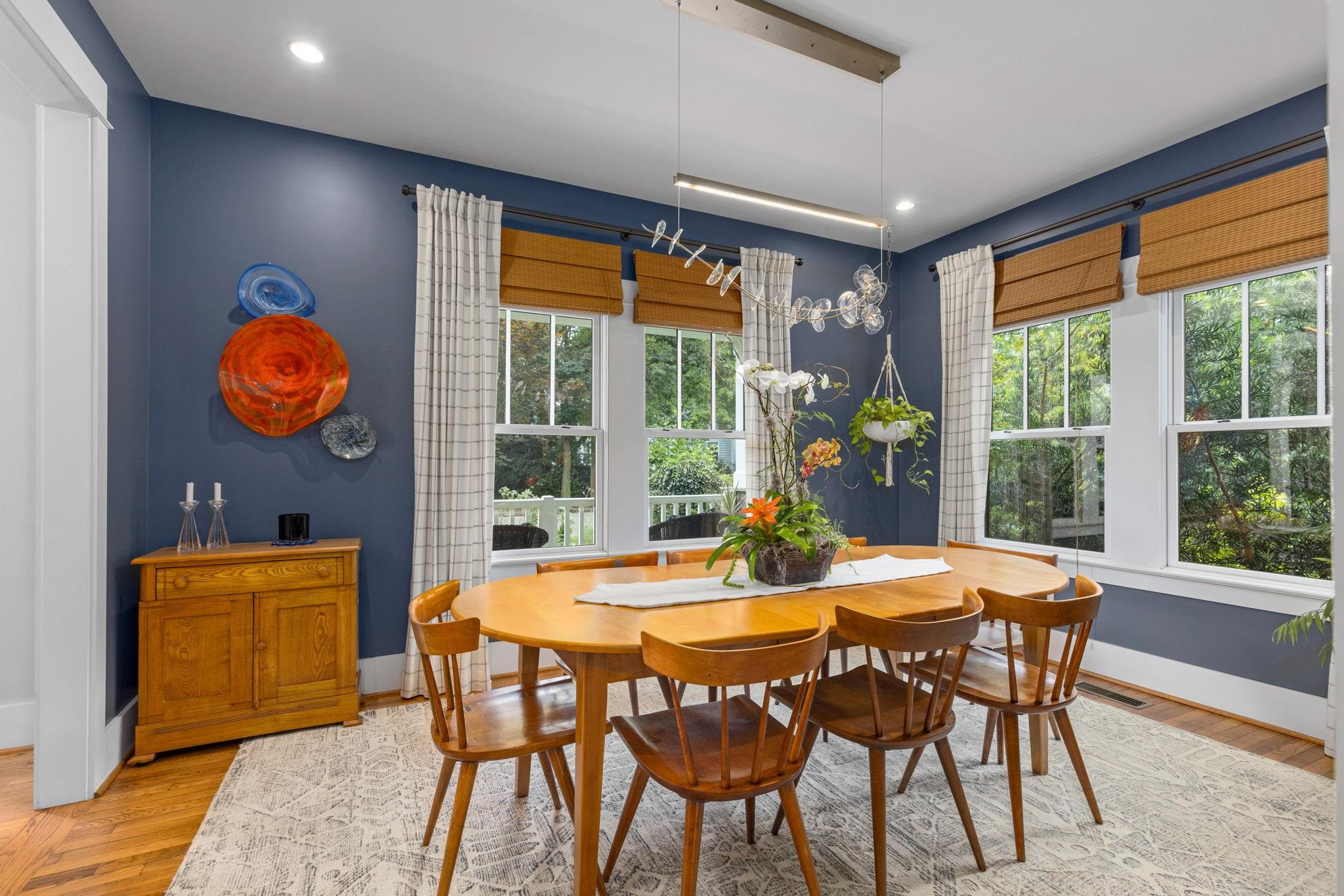 1610 Bickett Boulevard Raleigh, NC 27608 - Photo 14 of 44 a view of a dining room with furniture large windows and wooden floor