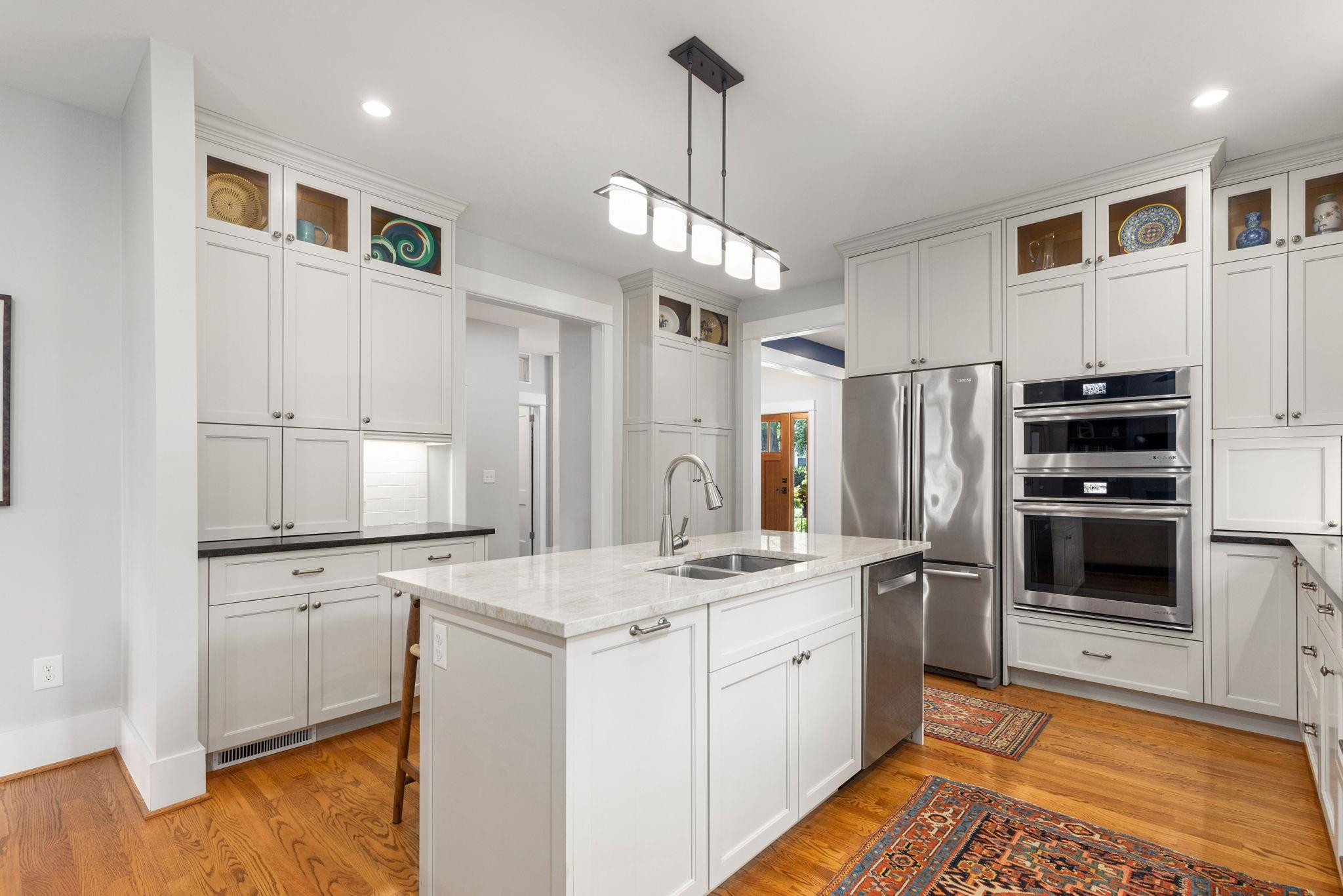 1610 Bickett Boulevard Raleigh, NC 27608 - Photo 17 of 44 a kitchen with white cabinets and stainless steel appliances