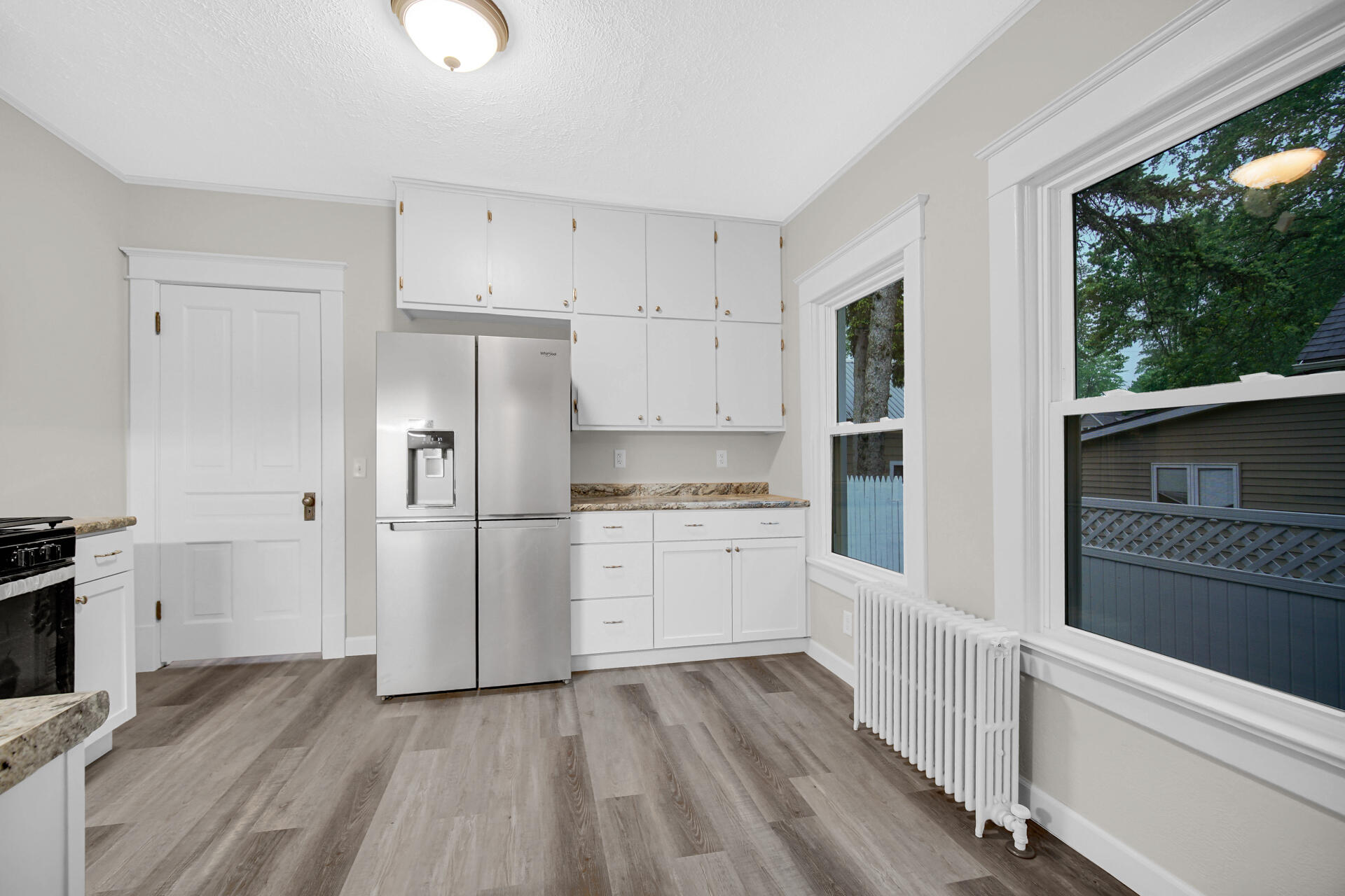 411 E Street La Porte, IN 46350 - Photo 11 of 33 a kitchen with white cabinets and wooden floor