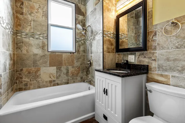 a bathroom with a granite countertop sink toilet and bathtub